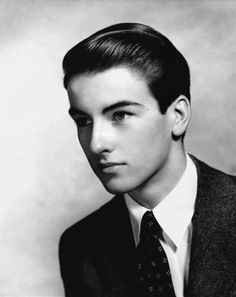 an old black and white photo of a young man in a suit with a tie