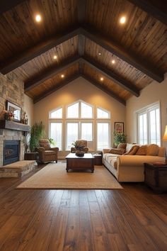 a large living room with wood floors and high ceilings, two couches on either side of the fireplace