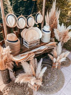 an outdoor table with hats and plates on it