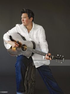 a man holding an acoustic guitar in his hands