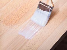 a wooden table with a paintbrush on it's side and wood grained surface