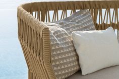 a wicker chair with two pillows on it