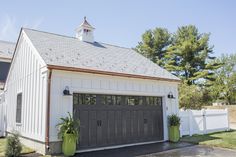 a white barn with two garages and a steeple