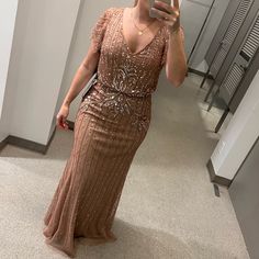 a woman taking a selfie in front of a mirror wearing a dress with sequins