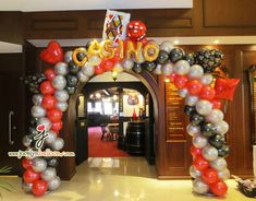 an entrance decorated with balloons and streamers for a casino themed birthday or baby shower