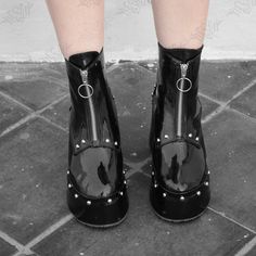 Step into edgy elegance with our Noir Platform Boots from the original Hesed Blackout collection.  Handcrafted by Salvadoran artisans, these round-toe ankle boots feature a 9cm heel at the back and 4cm platform at the front. Made from high-quality black faux patent leather, including a sole lining. Adorned with silver rivets, they open with a ring pull zipper. Customize colors and sizes. Perfect for casual outings, cosplay, or striking photo shoots. Please note that this product is shipped from Alternative Style Platform Boots With Studded Outsoles, Edgy Platform Boots With Grommets For Concerts, Edgy Grommet Platform Boots For Concerts, Edgy Grommeted Platform Boots For Concerts, Gothic Leather Platform Boots With Grommets, Gothic Platform Boots With Grommets, Punk Style Platform Boots With Grommets And Round Toe, Punk Style Platform Boots With Round Toe And Grommets, Rocker Style Rivets Platform Boots With Round Toe