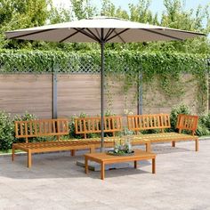 a wooden bench sitting under an umbrella on top of a stone floored patio area