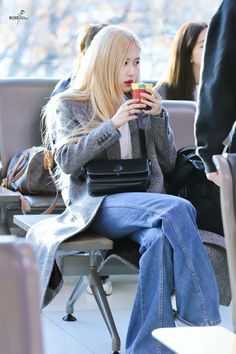 a woman sitting on a chair holding a cup