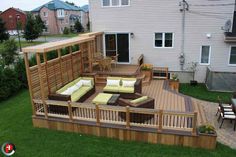 a wooden deck with furniture on it next to a house