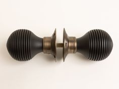 two black and gold knobs on a white wall