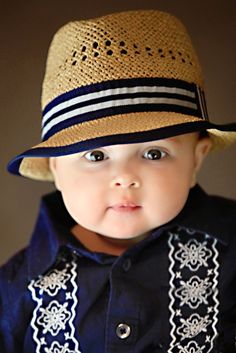 a little boy wearing a hat and blue shirt