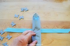 someone is cutting out some paper butterflies on the table