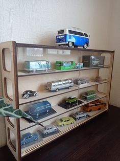 toy cars and buses are on display in a glass case with wood trimmings