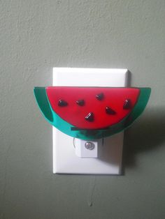 a watermelon shaped light switch plate on a wall