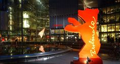 a large bear statue in front of a building at night