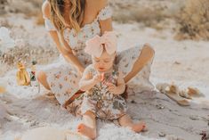 a woman kneeling down next to a baby