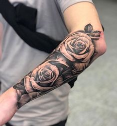 a man with a black and white rose tattoo on his arm, showing off the sleeve