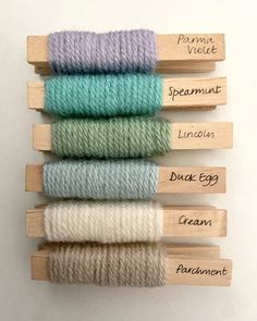 four skeins of yarn in different colors and sizes, labeled with labels on them