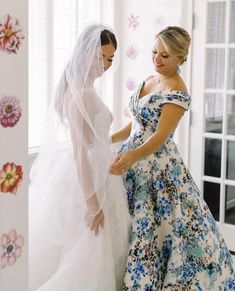 two women in wedding dresses looking at each other