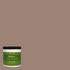 a can of green paint with the words behre color sample in black on it