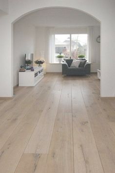 an empty living room with white walls and wood flooring is pictured in this image