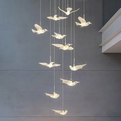 a chandelier made out of paper birds hanging from it's sides in a room