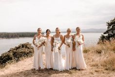 a group of women standing next to each other on top of a grass covered field