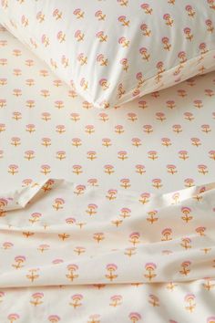 an image of a bed set with pink and yellow designs on it's sheets