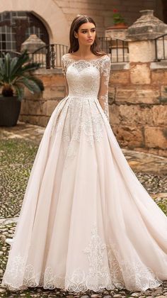 a woman in a wedding dress standing outside