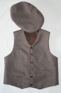 This is the perfect wool  vest for your little gentleman at home! It's made of excellent wool fabric. The color is dark brown herringbone with red and blue little stripes. This is a unique wool fabric, you won't find it in any brick or online store. The vest is lined in cotton fabric for your child comfort. Cotton is a healthy choice for your clothing. It has  six buttons that are made of wood, a natural clothing material. Size         Chest (inches) 2              22.1/4  3              22.1/2  4              23 5              23.1/4 6              23.3/4 7              24.3/4 8              26 9              27.1/4 10            28.1/2 12            29.3/4 If you need a bigger size (even adults) , please contact me, I am able to do any size. Thank you very much for visiting my shop. "Hau Dark Wash Cotton Vest With Pockets, Fitted Brown Wool Vest, Tailored Brown Wool Vest, Grey Wool Vest Men, Handmade Brown Felt Hat, One Size, Wool Caps, Natural Clothing, Clothing Material, Wool Vest