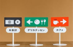 three signs with different languages on them sitting on top of a table next to each other