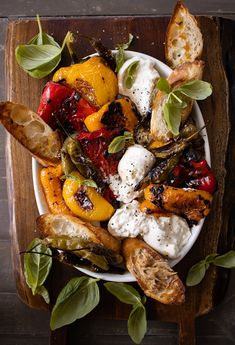 a white plate topped with lots of different types of food on top of a wooden table