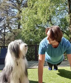 a woman is playing with her dog in the yard