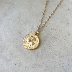 "A beautiful round Artemis and temple of Artemis double sided pendant in a rich matte finish gold. The relief on this pendant is gorgeous. The chain is a smooth cable in a 24k gold plated matte finish. Wear alone or layer with our other beautiful Greek pieces!  Size: 18 or 20\" Chain 25mm pendant Specs: Matte Finish pendant and chain 24k gold plated brass 24K gold plated chain Easy to use Clasp The richer color is due to the higher gold content in the plating. Wear and Care: Do not wear in chlorinated water. Wipe clean with a jewelry polishing cloth. Store your jewelry with care. This chain can tangle." Temple Of Artemis, Artemis Goddess, Ancient Greek Jewelry, Ancient Greek Coin, Cloth Store, Greek Coins, Greek Jewelry, Coin Necklace, Coin Pendant