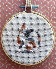 a cross stitch cat is on the ground