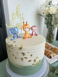 there is a cake that has animals on it and gold glitters around the edges