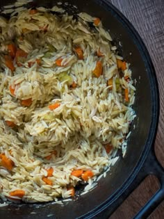 rice and carrots are mixed together in a skillet