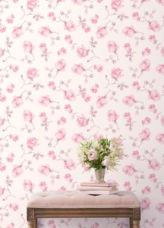 a vase with flowers sitting on top of a wooden bench next to a wallpaper