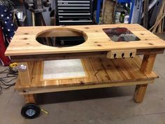 a table made out of pallet wood with a hole in the middle and wheels on each side