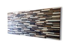 a wooden wall hanging on the side of a white wall with wood strips painted on it