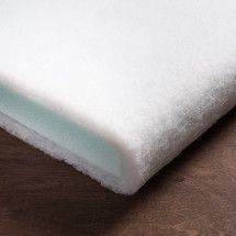 a close up of a white pillow on a wooden floor