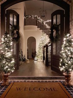 the entrance to a house decorated with christmas trees and garlands on either side of the door