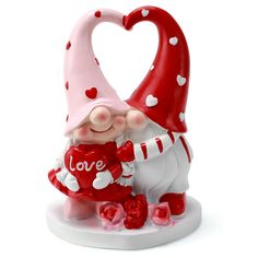 a red and white gnome figurine holding a heart