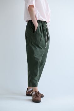 Manuelle Guibal Dandy Pant in color Military Road. Featuring an elastic waistband, pleats at front, pockets at sides and on back, ankle length, wide straight leg fit. 0 (Xsmall) - waist (before stretching elastic) - 22.5", length - 35" 1 (small) - waist (before stretching elastic) - 25", length - 35.5" 2 (medium) - waist (before stretching elastic) - 26.5", length - 36"3 (large) - waist (before stretching elastic) - 28", length - 36.5" 100% Cotton, Made in France. Green Tapered Leg Pants With Pull-on Style, Casual Wide Leg Pants With Gathered Waist, Relaxed Fit Pants With Gathered Waist For Spring, Casual Wide-leg Bottoms With Gathered Waist, Casual Wide Leg Bottoms With Gathered Waist, Casual Wide Leg Pants With Pleated Waist For Spring, Relaxed Fit Cotton Bottoms With Gathered Waist, Casual Cotton Pants With Gathered Waist, Cotton Bottoms With Relaxed Fit And Gathered Waist