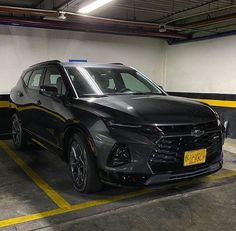 a black chevrolet suv parked in a garage