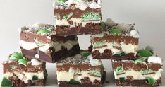 several pieces of chocolate and marshmallow cake stacked on top of each other with green leaves