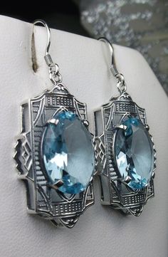 "Simulated Aquamarine Earrings Braid Design#E19 Custom Made Inspired by the Art Deco movement of the early 1900s, I now offer these lovely Antique reproduction earrings in sterling silver. Each stunning 8ct flawless Simulated Blue aquamarine is 16mm long (just over 5/8th\") and 12mm in width (1/2\"). The aquamarines have perfect color and clarity. The earrings are 1 3/4th inches long. Notice the beautiful design of the Deco filigree setting. These earrings were fashioned from an Art Deco 1930s b Oval Art Deco Earrings For Formal Occasions, Art Deco Oval Earrings For Formal Occasions, Art Deco Hallmarked Earrings As Gift, Formal Oval Art Deco Earrings, Vintage Drop Earrings With Matching Set, Vintage Drop Jewelry Set With Matching Earrings, Vintage Drop Earrings For Pierced Ears, Art Deco Hallmarked Drop Earrings, Art Deco Drop Earrings For Anniversary