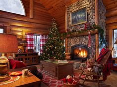 a living room filled with furniture and a christmas tree in front of a fire place