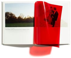 an open red book with two photos on the cover and one in the middle showing a man and woman