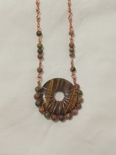 Every inch of this necklace is handmade, it is totally unique even down to the chain. Made with copper wire, a beautiful Tigerseye stone, and high quality Unakite beads. The pendant is 1 1/2 x 1 1/2 inches, and the chain is 20 inches, with a hook and eye clasp. Handmade Round Earthy Necklaces, Handmade Earthy Round Necklaces, Handmade Round Earthy Necklace, Handmade Unique Wire Necklaces, Unique Handmade Wire Necklaces, Bohemian Adjustable Wire Necklaces, Bohemian Adjustable Wire Necklace, Adjustable Bohemian Wire Necklace, Handmade Copper Wire Jewelry With Round Beads